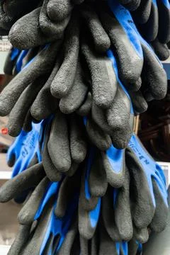 Collection of work gloves in different sizes arranged neatly on a display rack Stock Photos