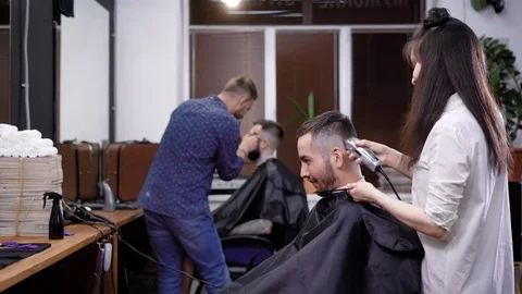 Collective of barbers at work. View of scene of work at barbershop. Customers Stock Footage