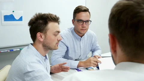 Collective of office workers discuss a project, businessmen working with Stock Footage 137734177