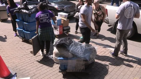 College and university students heading back to school moving in to campus dorm Stock Footage