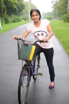 College girl on her cycle, at the middle of road. Foto stock