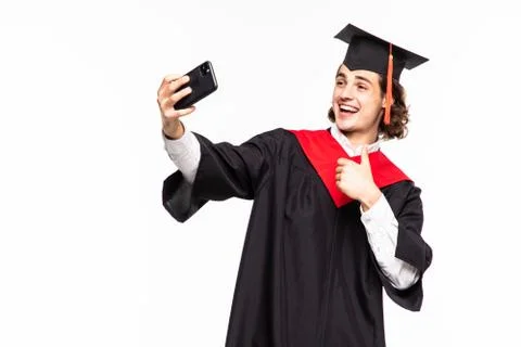 College graduate taking a selfie with cell phone holding a diploma on white b Stock Photos