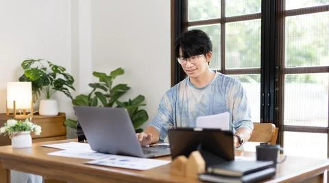 College student is analyzing data or doing homework assignments in own house, Stock Photos