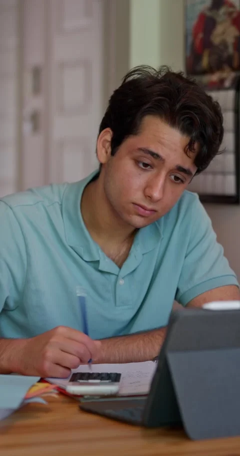 College Student Checking Calculations At Home Using Calculator And Tablet Stock Footage 331204798