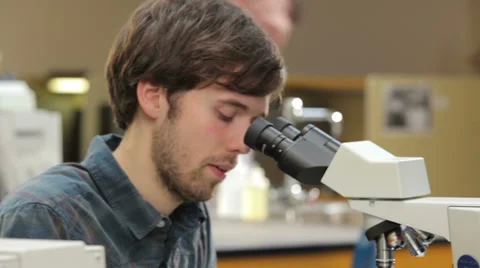 College student looks through a microscope during a lab class Video stock 33881301