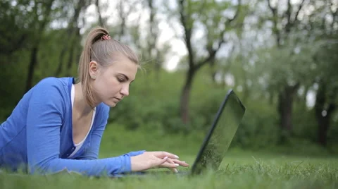 College Student Lying Down On The Grass Working On Laptop At Campus Stock Footage 62844916
