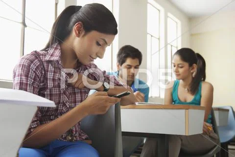 College Student Reading Sms On Mobile Phone