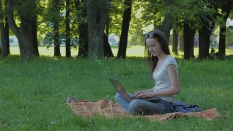 College student sits down on the plaid in the forest and working on laptop Stock Footage 75858205