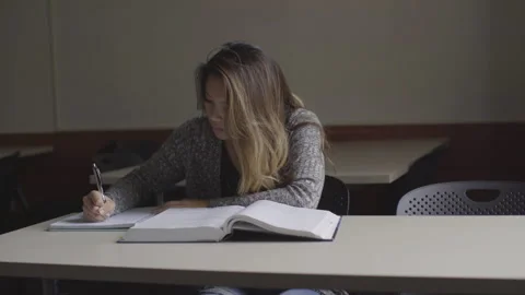 College Student Takes Notes While Reading Textbook Stock Footage 208720476