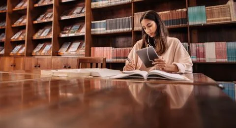 College student taking notes from reference book Stock Photos