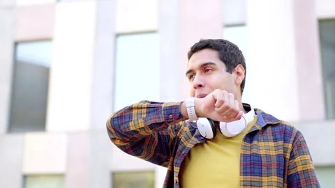 College student using a smart watch standing outside the campus Video stock 258326273