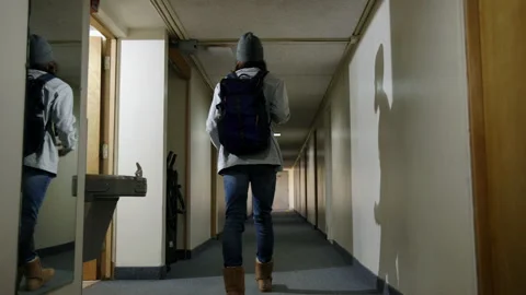 College Student Walks Down Dormitory Hallway Stock Footage 172368603
