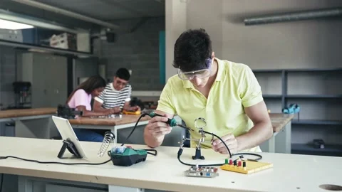 College Student working on electronics circuit, learning science technology in Stock Footage 238477974