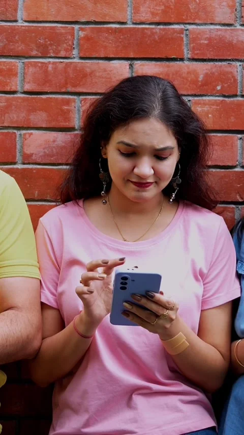 College students busy using smartphone on campus stairs or against wall Stock Footage 342385174