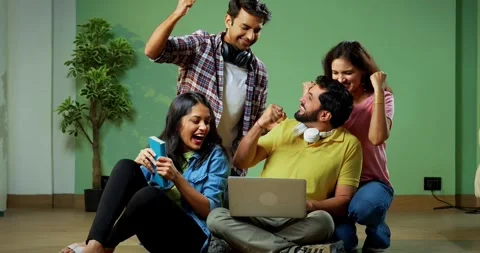 College students celebrate success while seating on floor using laptop Stock Footage 342384038