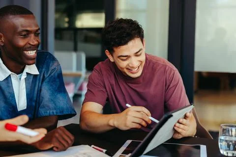 College students engaged in collaborative learning with technology, enjoyin.. Foto stock