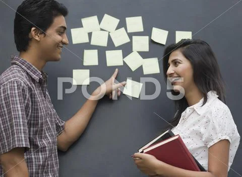 College students smiling in front of a bulletin board Stock Photos