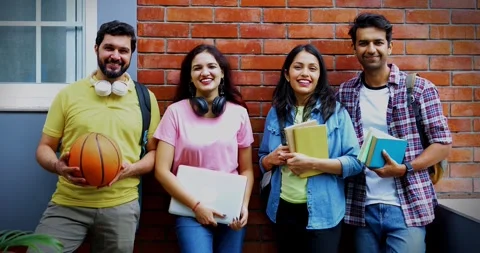 College students standing against wall and smiling during break Stock Footage 342384575