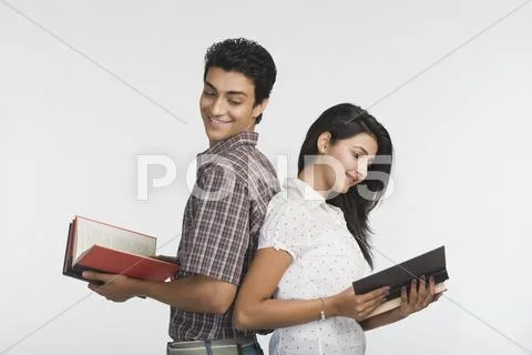 College students standing back to back and reading books Stock Photos