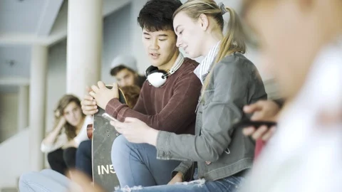 College students talking and using phone on steps Stock Footage 106318264