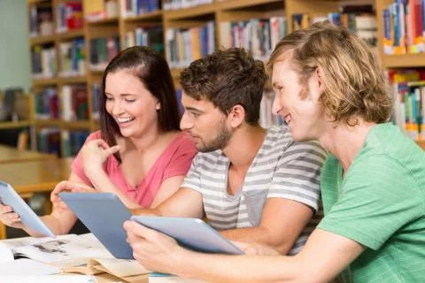 College students using digital tablets in library 写真素材