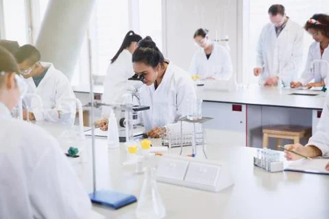 College students using microscope conducting scientific experiment in laboratory 写真素材