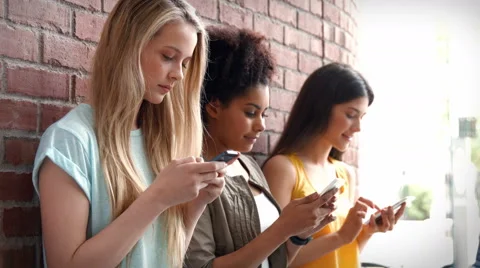 College students using their phones in a row Vidéo 53106701