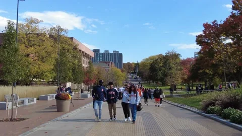 College students  visitors walking on a windy Fall day in Syracuse University Stock Footage 220169062