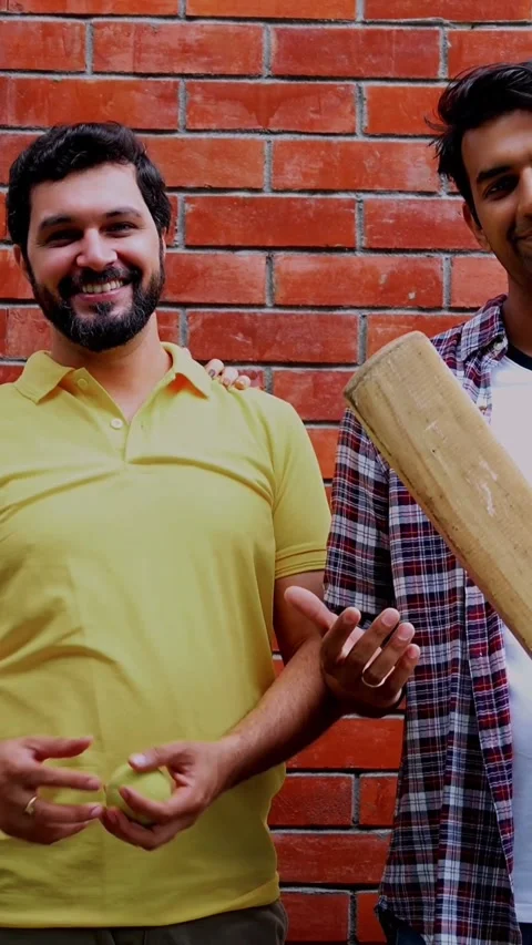 College team with bat ball poses confidently against red brick wall in campus 스톡 동영상 342385171