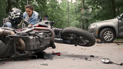 Collision between motorcycle and car on the road. Girl driver hit motorcyclist Stock Footage 233190828
