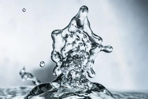 Collision of falling water drops creates unique bright triangle water sculpture Stock Photos