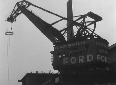 COLOGNE, GERMANY - 1945: Hook and cable - lattice crane towers above Ford Stock Footage 344600224