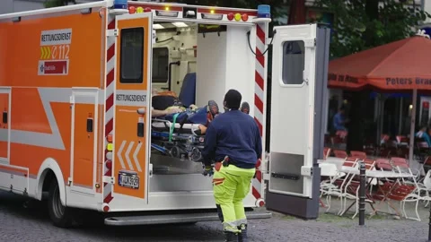 Cologne, Germany - 22 Jun, 2022: Paramedics work with a stretcher giving firs Stock Footage 218193665
