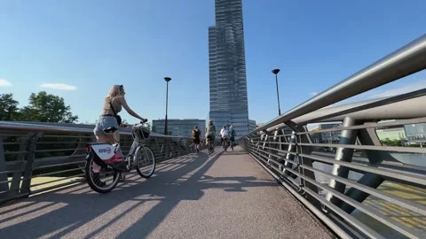 Cologne, Germany - Jul 20, 2025: People walking, cycling by footbridge in Med Video stock 321307704
