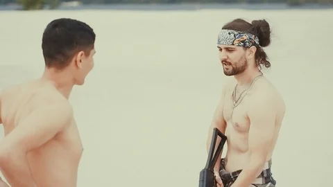 Colombian gangster holds a firearm in his hands, topless, threatens with a Stock Footage 98607222