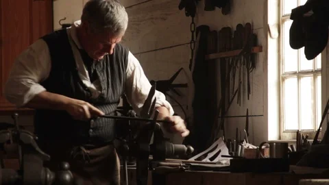 Colonial Blacksmiths Working on Iron Bar with tools - Recreation Stock Footage 105604709