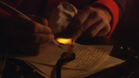 Colonial Soldier writes with quill at Table by candle light Stock Footage 91354897