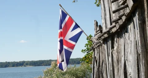 Colonial union jack flag flying in the wind next to river blue skies Video stock 171183228
