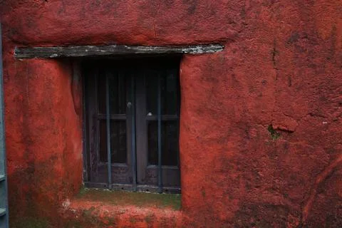 Colonial window with iron bars in weathered red stucco wall in Colonia del .. Stock Photos