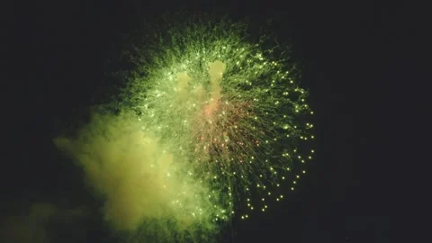 Color changing firework bursting from bright red to vibrant green in dark sky Video stock 340632791