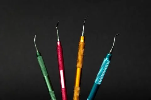 Color coded dental modeling instruments on black background Stock Photos