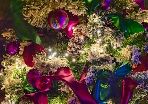 Color decorative bauble on pine tree brenches among the lights Stock Photos