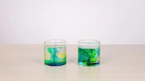 Color Diffusion in Water Glasses During Science Experiment Stock Footage 318943226