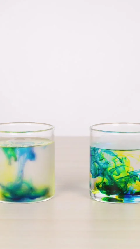 Color Dye Diffusing in Glass of Water on Table Stock Footage 318720182