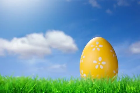 Color easter egg in the grass against blue sky Fotos de archivo