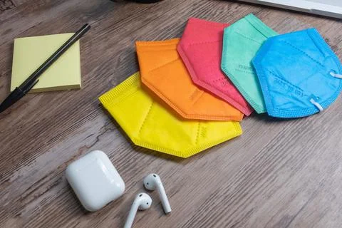 Color facemasks on a desktop with office elements Foto stock