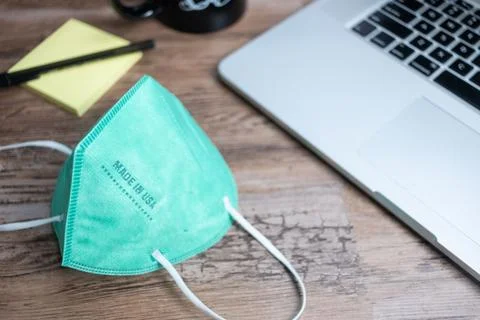 Color facemasks on a desktop with office elements Foto stock