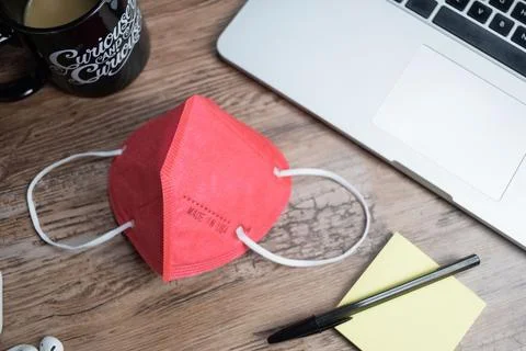 Color facemasks on a desktop with office elements Foto stock