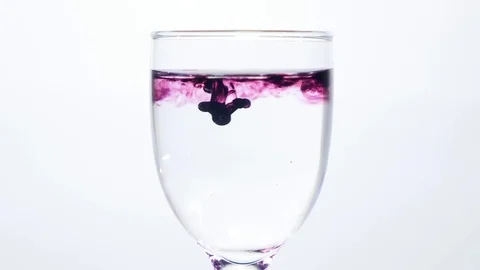Color Ink flowing in glass of water on white background Stock Footage
