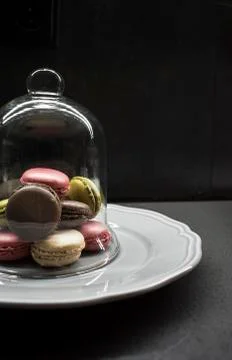 Color macaroon cookies on plate, dark background Stock Photos
